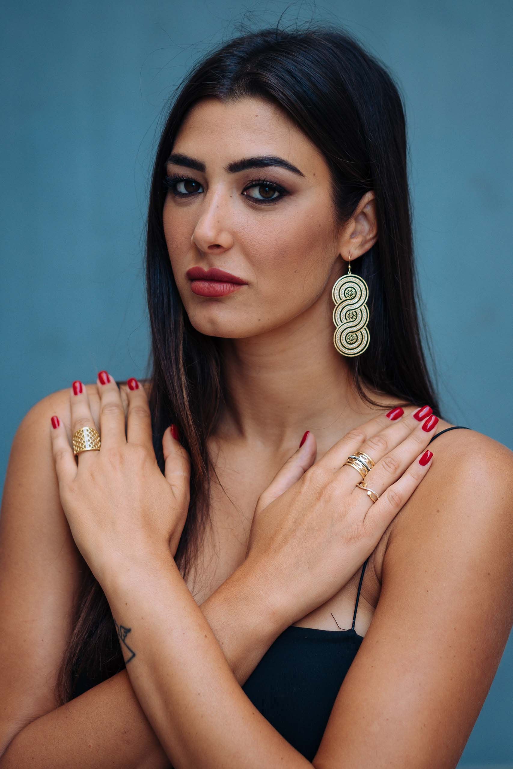 Foto con modella di orecchini pendenti formati da tre spirali. Gli orecchini vengono graffiati a mano, e bagnati in vero oro con componenti in argento chiaro.