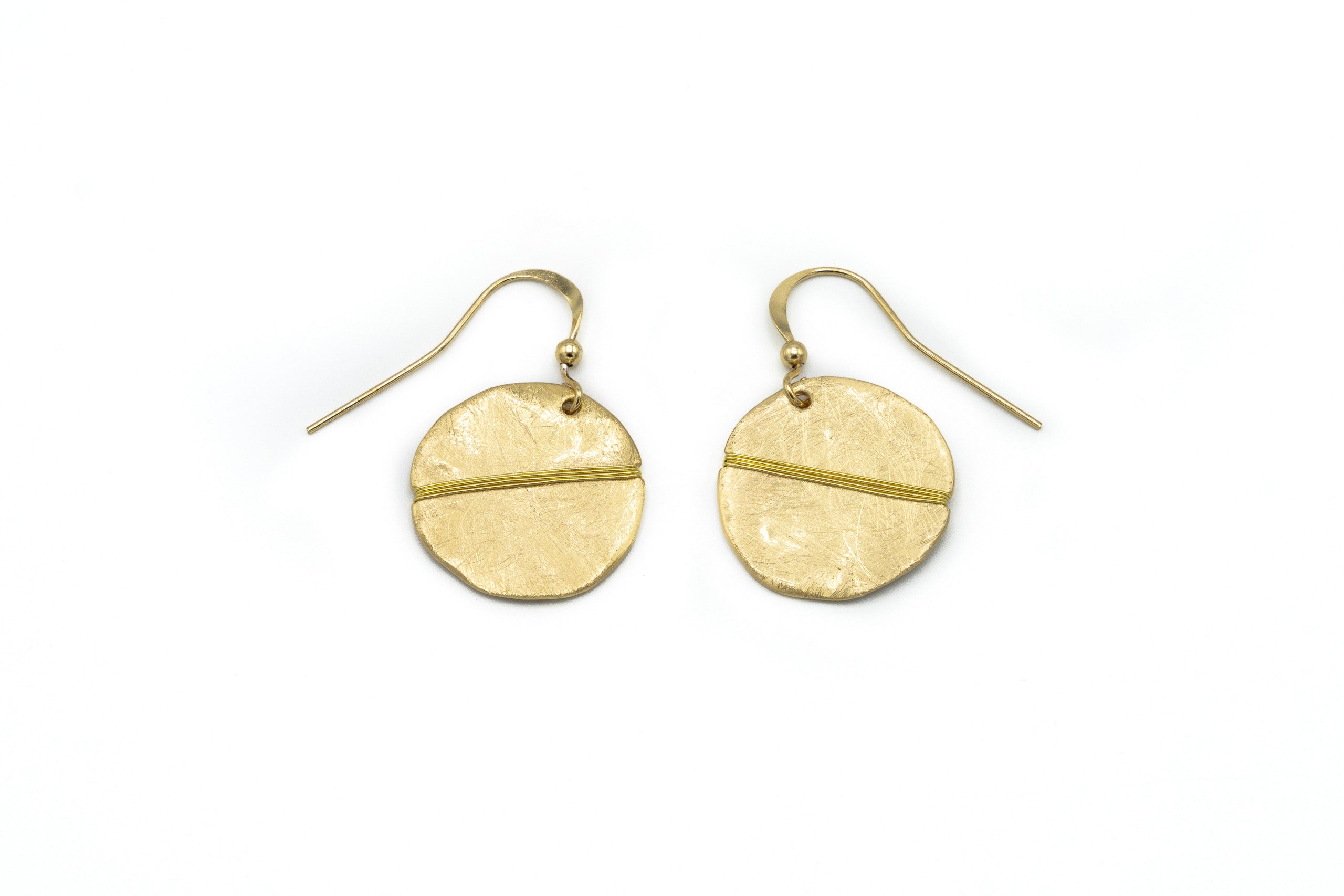 Orecchini pendenti tondi graffiati a mano, e filo in ottone avvolto diagonalmente. con filigrana interna. Vengono bagnati in vero oro satinato.  Diametro: 2 cm.  Materiale: ottone con bagno in oro. Collezione Cleopatra di KLK.