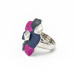 Anello elasticizzato dipinto a mano con tre smalti.  Misura: da 17 mm + (multimisura elasticizzato)  Larghezza max:  3 cm  Materiale: zama con bagno in oro rosa o argento  Tonalità smalti: blu, viola, beige o fucsia, blu, grigio. Collezione Minerva di KLK.