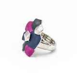Anello elasticizzato dipinto a mano con tre smalti.  Misura: da 17 mm + (multimisura elasticizzato)  Larghezza max:  3 cm  Materiale: zama con bagno in oro rosa o argento  Tonalità smalti: blu, viola, beige o fucsia, blu, grigio. Collezione Minerva di KLK.