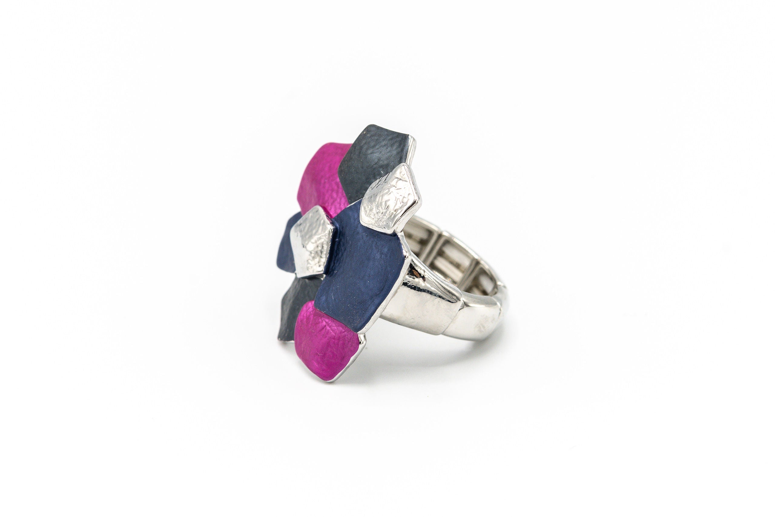 Anello elasticizzato dipinto a mano con tre smalti.  Misura: da 17 mm + (multimisura elasticizzato)  Larghezza max:  3 cm  Materiale: zama con bagno in oro rosa o argento  Tonalità smalti: blu, viola, beige o fucsia, blu, grigio. Collezione Minerva di KLK.