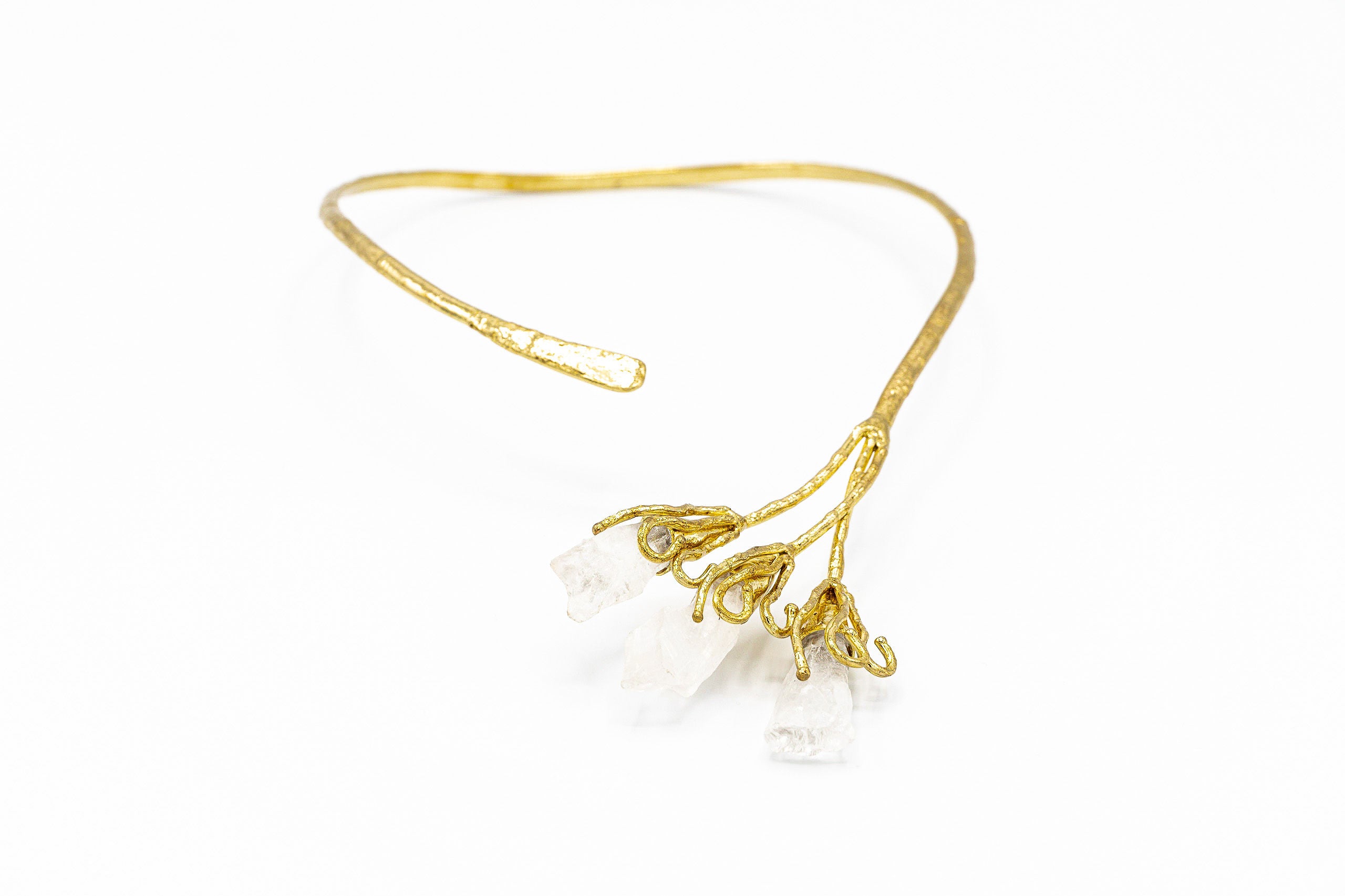 Collana semi-rigida regolabile fatta a mano, in ottone con cristalli.   Benefici del Cristallo:  Rende sinceri e imparziali. Rafforza le capacità di comprendere gli altri e di affermare la propria natura più profonda. Stimola l'individuo a conoscere sé stesso.   Materiali: ottone, cristallo