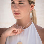 Collana lunga regolabile con tre tondi in tre bagni diversi. Lunghezza: 84 cm (regolabile)  Altezza tre tondi: 7,2 cm  Materiale: zamak con bagno in argento, rodio e oro. Foto con modella. Collezione Venere di KLK.